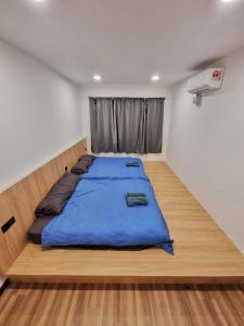 a bedroom with a large bed with a blue comforter at Kota Kinabalu family Home in Kota Kinabalu