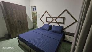 Schlafzimmer mit einem Bett mit blauer Decke in der Unterkunft Boegas View Guesthouse in Vaikaradhoo