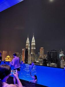 a group of people taking pictures of the city at night at The platinum KLCC By Garden Suites in Kuala Lumpur