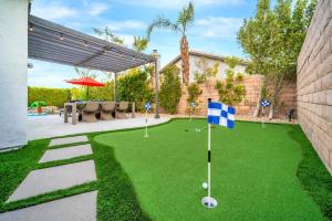 un campo de golf con bandera en un patio en NEW! The Blue Cactus - Pool, Spa, Game Room, en Palm Springs