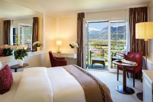 a hotel room with a bed and a balcony at Park Hotel Sonnenhof - Relais & Châteaux in Vaduz