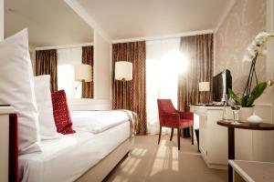 ein Hotelzimmer mit einem weißen Bett und einem Fenster in der Unterkunft Park Hotel Sonnenhof - Relais & Châteaux in Vaduz