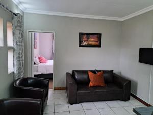 a living room with a couch and a chair at Partridge Place in Kempton Park