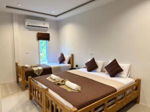 a bedroom with two beds and a window at Suntalee House in Nai Yang Beach