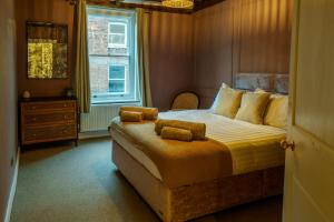 a bedroom with a bed with yellow sheets and a window at The Castle City Centre Apartment in Canterbury