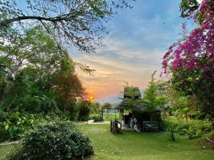 a view of a garden with a sunset in the background at Fern Resort Mae Hong Son in Mae Hong Son