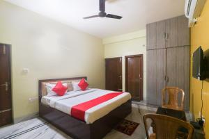 KhandagiriにあるOYO Devi Residencyのベッドルーム1室(赤い枕のベッド1台付)