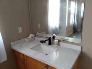 a bathroom with a white sink and a mirror at Waterloo Master bedroom with attached bathroom in Waterloo