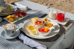 a table with a plate of breakfast food and a cup of coffee at Blanco Beach Resort Malapascua in Malapascua Island