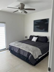 1 dormitorio con 1 cama y ventilador de techo en Casa Arcana (3 minutos del consulado), en Ciudad Juárez
