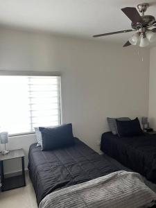 1 Schlafzimmer mit 2 Betten und einem Deckenventilator in der Unterkunft Casa Arcana (3 minutos del consulado) in Ciudad Juárez