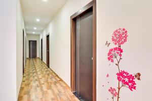 korytarz z różowymi kwiatami i motylami na ścianie w obiekcie Collection O Pratik Inn w mieście Chinhat