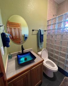 a bathroom with a sink and a toilet and a mirror at Casa Corazon Striking Beach Home in Utila