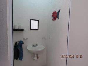 a bathroom with a sink and a red mask on the wall at Casa Turquesa in Cancún