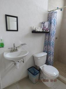 y baño con aseo y lavamanos. en Casa Turquesa, en Cancún