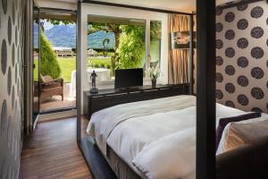 a bedroom with a bed and a screened in porch at Park Hotel Sonnenhof - Relais & Châteaux in Vaduz +120 photos