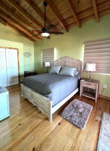 a bedroom with a large bed and a wooden floor at Casa Corazon Striking Beach Home in Utila
