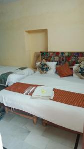 two beds sitting in a room with at Neem Guest House Jaisalmer in Jaisalmer