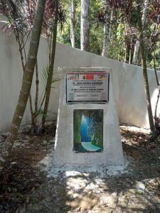 un monumento con un cartel delante de una pared en Centro ecoturistico Arco del Tiempo, en Cintalapa de Figueroa