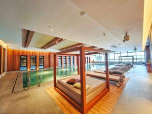 a swimming pool with two beds in a room at Oakwood Suites Chongli in Chongli