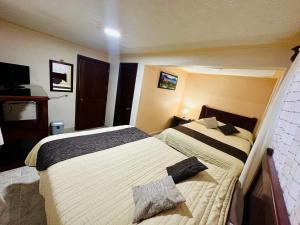 Postel nebo postele na pokoji v ubytování Hotel Monarca Tlalpujahua