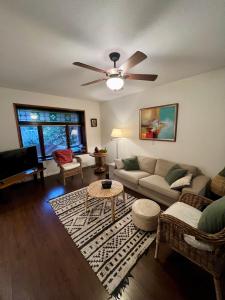 a living room with a couch and a ceiling fan at Charming Heritage Home with Mountain and City Views in Vancouver