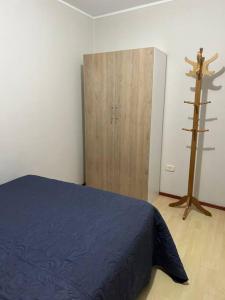 a bedroom with a blue bed and a wooden door at Departamento Lucas in Trujillo