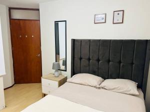 a bedroom with a large bed with a black headboard at Departamento Lucas in Trujillo