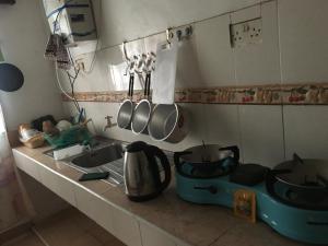 a kitchen counter with pots and pans and a sink at Tropical paradise in Mombasa