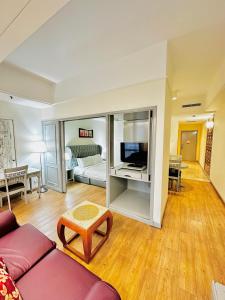 a living room with a couch and a tv at Regal Residences At Berjaya Times Square in Kuala Lumpur