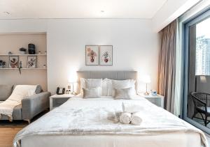 a bedroom with a large bed with two towels on it at 5-Star Studio at The Address Marina, Mall Access in Dubai