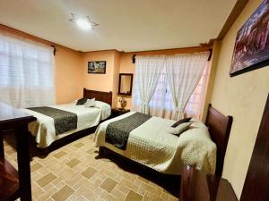 Postel nebo postele na pokoji v ubytování Hotel Monarca Tlalpujahua