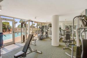 a gym with cardio equipment and a swimming pool at Pelican Beach Paradise! in Destin