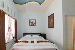 a bedroom with a bed in a white room at Puri Karimunjawa RedPartner in Karimunjawa