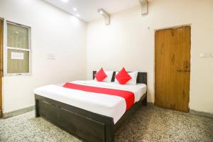 una camera da letto con un grande letto con cuscini rossi di OYO Hotel Kalyug Palace a Bhopal
