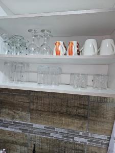 a shelf filled with glasses and wine glasses at Déjàvu at the Bay in Richards Bay
