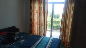 Schlafzimmer mit einem Bett und einem Fenster mit Vorhängen in der Unterkunft Casa Condominio Flandes / Giradot in Flandes