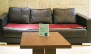 a leather couch with a table with a sign on it at Hotel Mani Ram Palace Agra in Agra