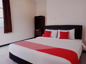 a bedroom with a large bed with red pillows at Rahayu Residence Syariah Kediri in Kediri