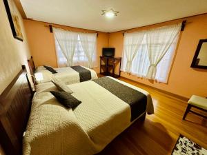 Cette chambre comprend 2 lits et 2 fenêtres. dans l'établissement Hotel Monarca Tlalpujahua, à Tlalpujahua de Rayón