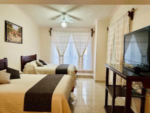 Cette chambre comprend 2 lits et une télévision à écran plat. dans l'établissement Hotel Monarca Tlalpujahua, à Tlalpujahua de Rayón