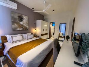 a bedroom with a large bed and a desk at Marine Breeze Residencies in Colombo