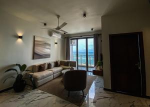 a living room with a couch and a view of the ocean at Marine Breeze Residencies in Colombo