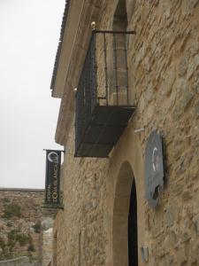 - un bâtiment en pierre avec un balcon et un panneau dans l'établissement Hostal Doña Blanca, à Sigüenza