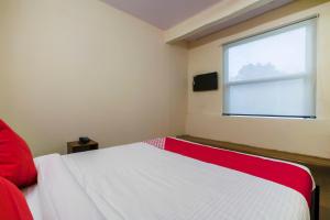 a bedroom with a white bed and a window at Alpine glow Zenith in Hyderabad