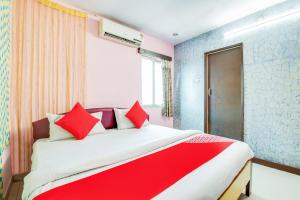a bedroom with a large bed with red pillows at SPOT ON Hotel Wonderfull Inn in Visakhapatnam