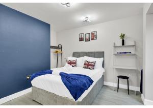 a bedroom with a king sized bed with blue walls at Explorer’s Studio - Comfort, Peace, Convenience in London