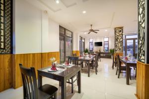 a dining room with tables and chairs in a restaurant at RAON Hoian Beach in Hoi An