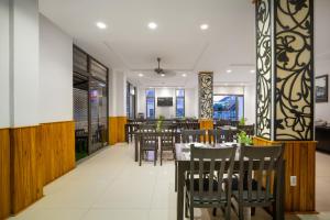 ein Restaurant mit Holzwänden, Tischen und Stühlen in der Unterkunft RAON Hoian Beach in Hoi An