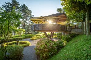 a bench in a garden with the sun shining at Park Hotel Sonnenhof - Relais & Châteaux in Vaduz
